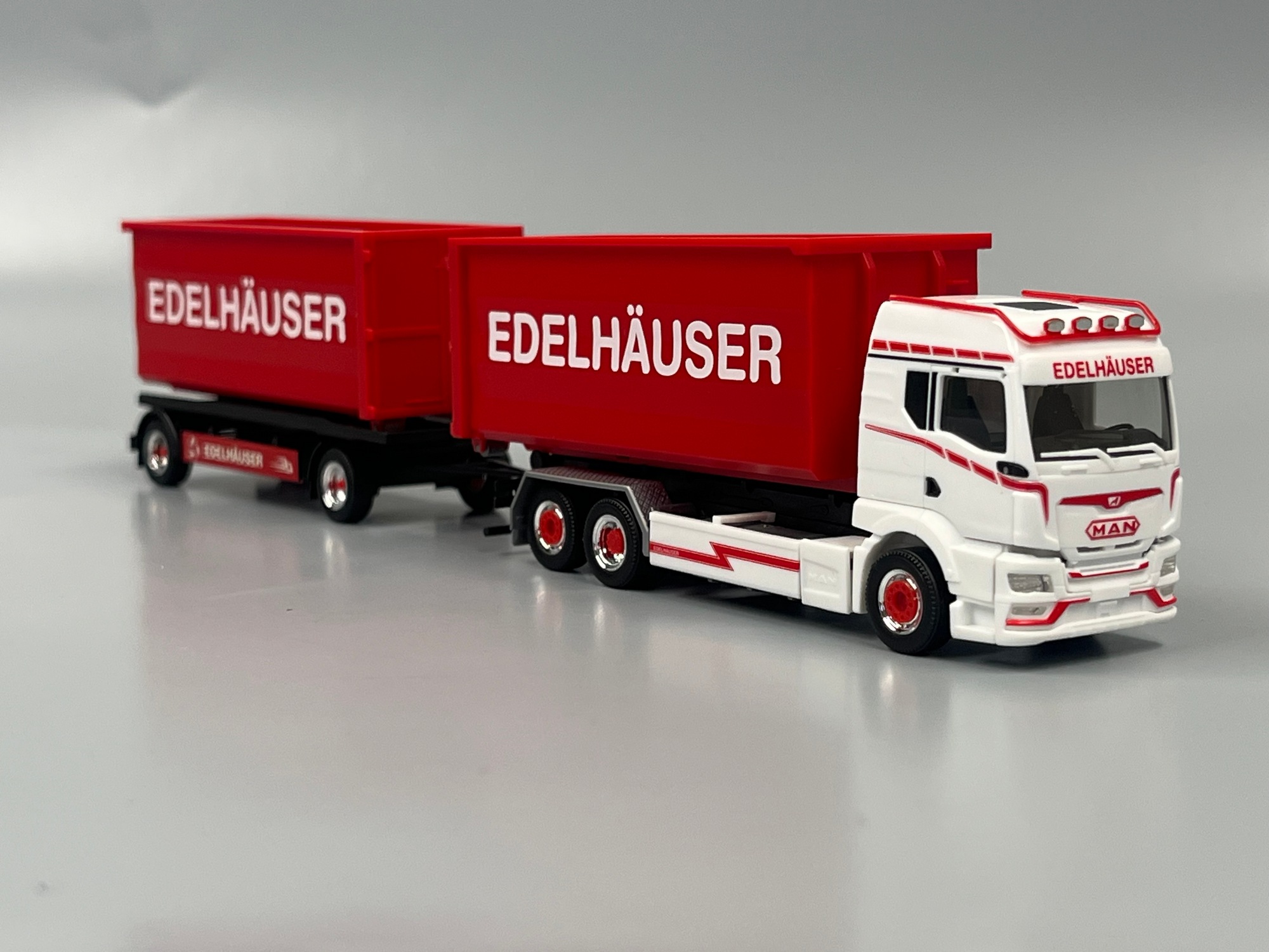 319317 - Herpa - 	MAN TGS TM Abrollmulden-Hängerzug "Edelhäuser"